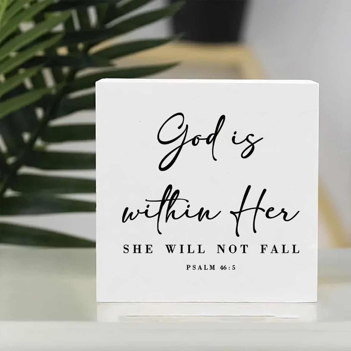 A white rectangular ornament featuring the scripture God is within Her She will not fall from Psalm 46:5