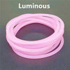 A set of ten luminous pink silicone bracelets coiled together on a dark surface.