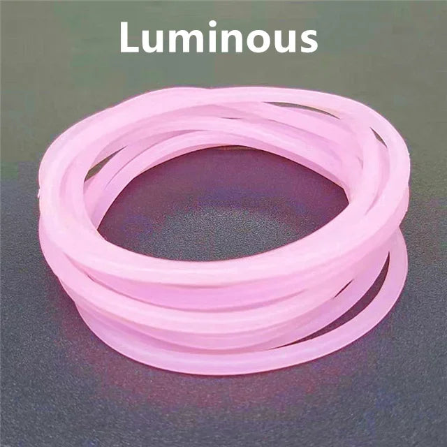 A set of ten luminous pink silicone bracelets coiled together on a dark surface.