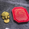 A golden tortoise figurine is displayed next to a red leather pouch embossed with Chinese characters.