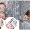 A young girl and woman posing in front of a silver metallic foil fringe curtain backdrop with silver sunglasses and decorativ