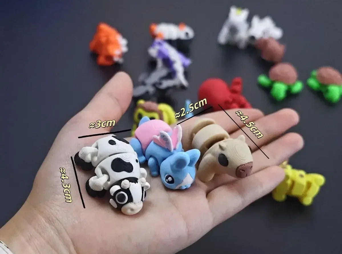A hand holds several small, colorful 3D printed animal figurines, including a cow, a blue dragon, and other small animals.