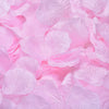 A close-up of pink artificial silk rose petals scattered on a surface.