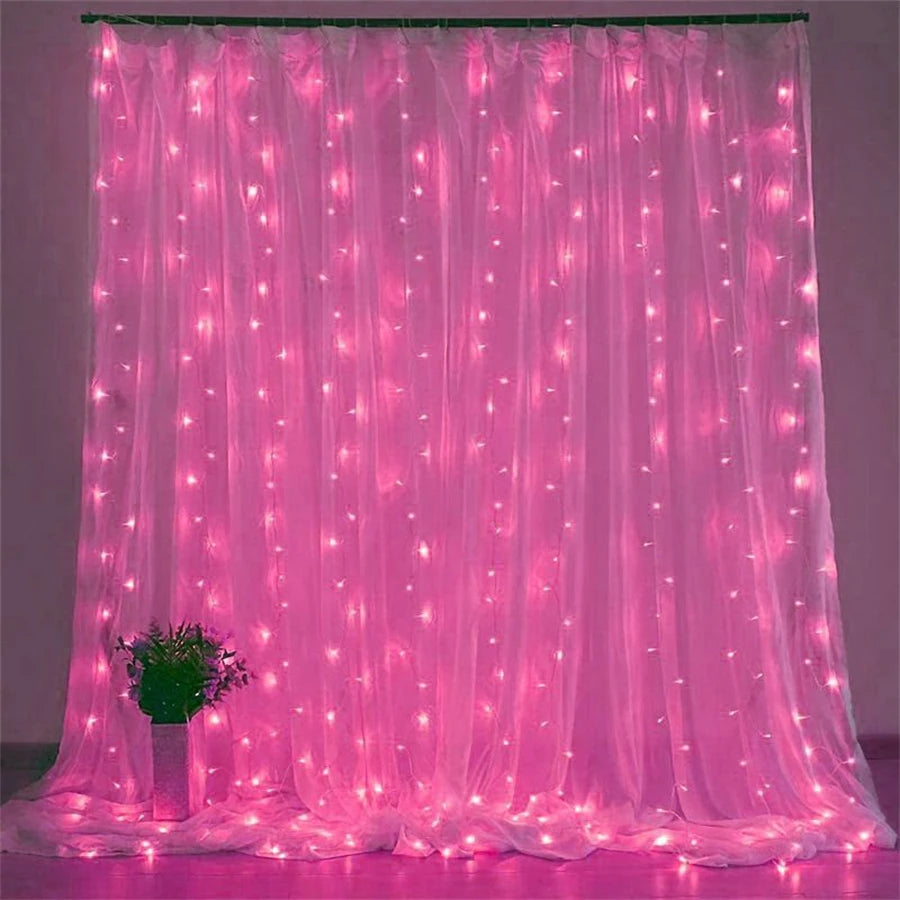 Pink sheer curtain illuminated by numerous glowing LED string lights