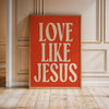 A framed piece of retro Christian wall art featuring the text LOVE LIKE JESUS in white lettering on an orange background.