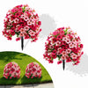 A vibrant display of artificial pink and red flowers shaped into topiary balls, shown in full bloom and planted in a green la