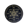 A black circular board with letters and words arranged in a geometric pattern for divination or meditation.
