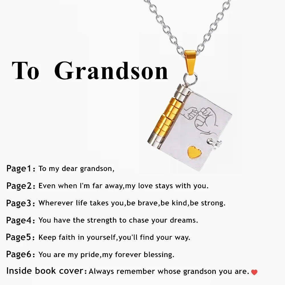 A gold chain necklace with a pendant engraved with a message to a grandson on a clear card.