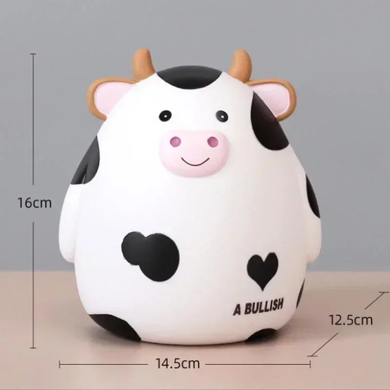 A white cartoon cow figurine with black spots and pink features, used as a piggy bank or coin holder.