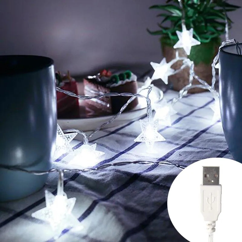 String of white LED star fairy lights draped across a white cloth with a USB connector visible.