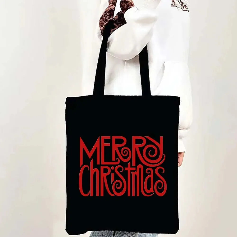 A black tote bag featuring red text that reads Merry Christmas