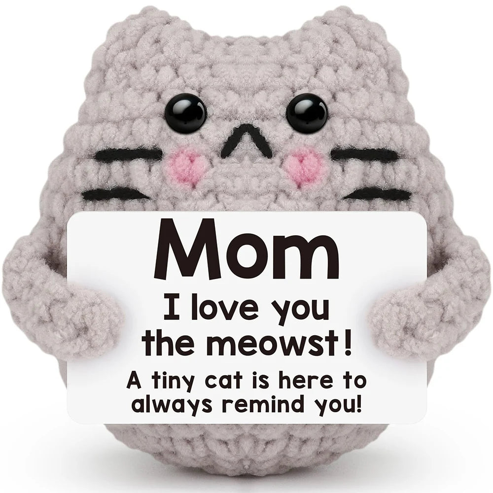 A handmade gray crochet cat doll with black stripes and a card that says I love you the meowst