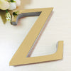A golden letter Z cutout used as a mirror wall decal against a light wooden background.
