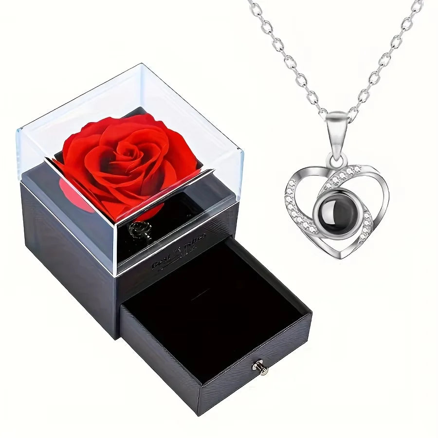Un coffret cadeau avec une rose rouge conservée et un collier en forme de cœur argenté.