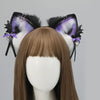 A pair of black and purple furry fox ears headband with heart accents displayed on a mannequin head.