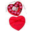 A red heart-shaped box filled with rose flowers and a white bear soap gift set.