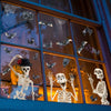 A window display featuring Halloween skull and bat stickers on glass panels.