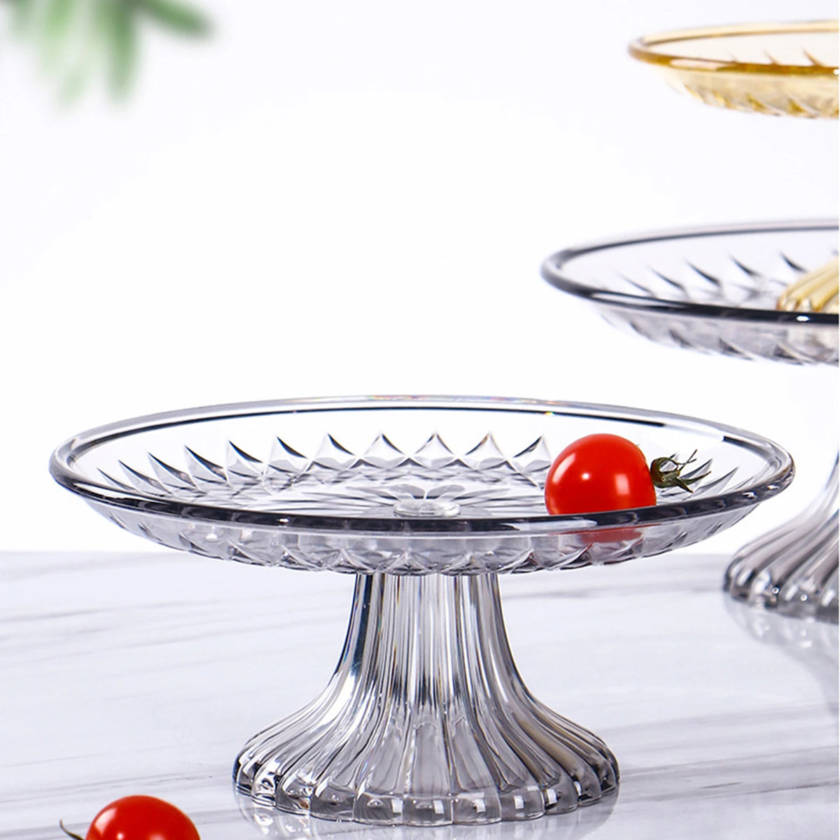Clear acrylic serving plates for fruit, desserts, and appetizers with a red tomato