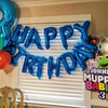 Blue foil letter balloons spelling HAPPY BIRTHDAY decorating a window for a birthday party