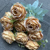 A bouquet of nine realistic silk roses in shades of beige and peach with green foliage.