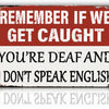 A distressed red and white sign with text that reads Remember if we get caught you're deaf and I don't speak English