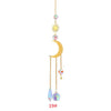 Décoration suspendue avec un soleil, une lune et des charms en cristal sur une chaîne dorée.