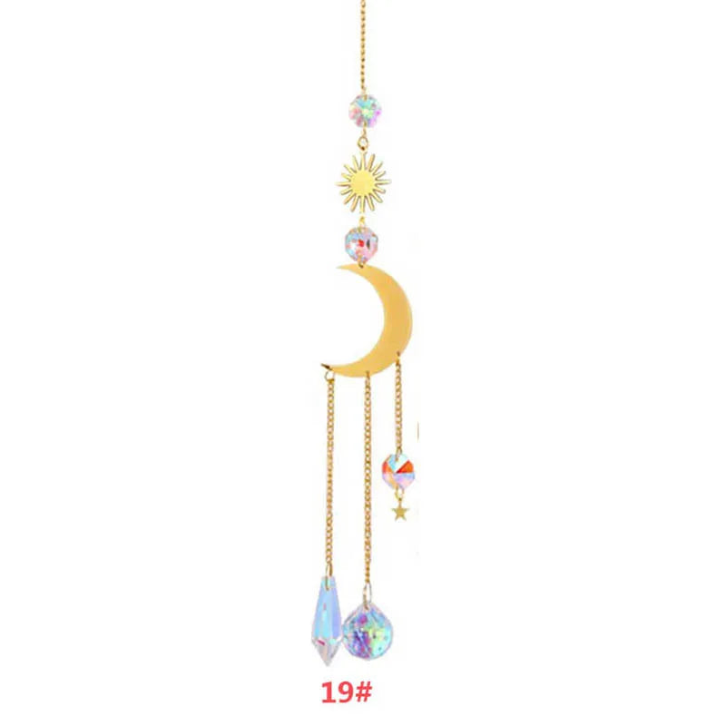 Décoration suspendue avec un soleil, une lune et des charms en cristal sur une chaîne dorée.