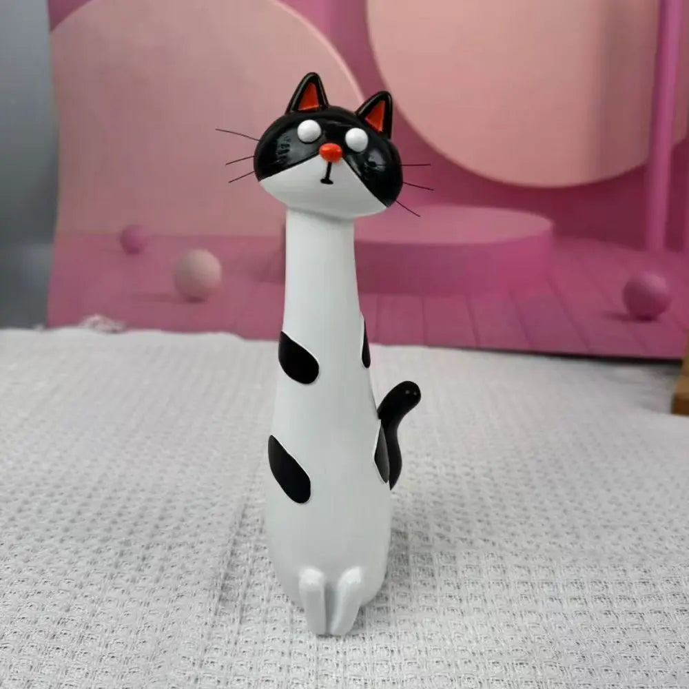 A white and black cat-shaped resin vase for home decor is displayed on a white textured surface.