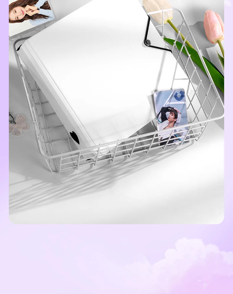 A white wire mesh organizer tray holding a ring binder for trading cards and photos.