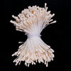 A bundle of mini artificial flower stamens in a creamy white color tied together.