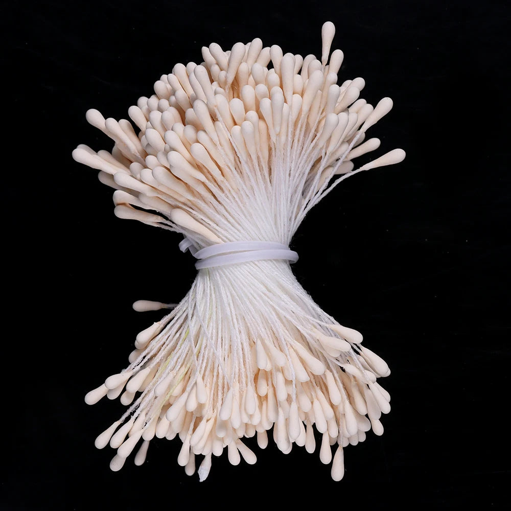 A bundle of mini artificial flower stamens in a creamy white color tied together.