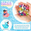 A hand holds a pile of colorful resin cruise ducks with sunglasses for decorating potted plants.