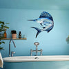A metal fish wall art decoration featuring a blue and silver fish mounted on a light blue wall above a bathroom sink.