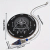 A black wooden pendulum board with a crystal pendulum and accompanying chain.