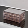 Clear acrylic jewelry organizer with three drawers shown in a reflection.