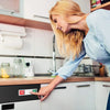 A woman's hand points to a DIRAN magnet sign on the door of a dishwasher.