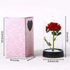 A pink box containing an eternal rose displayed inside a clear glass dome.