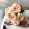 A bouquet of artificial silk roses and peonies in soft pink and cream colors.