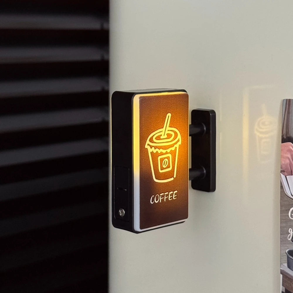 A black magnetic fridge decor featuring a glowing orange outline of a coffee cup and the word COFFEE.