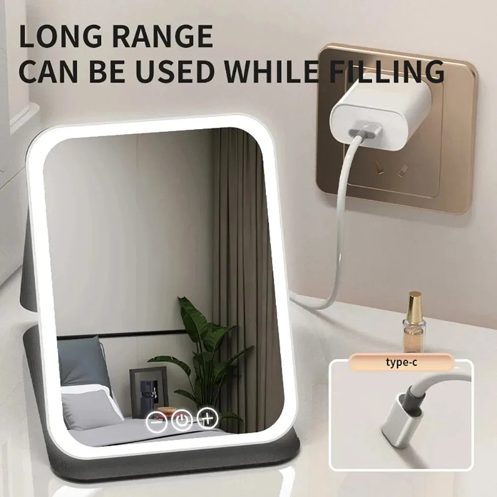 A long range filling vanity mirror with a rectangular frame and LED lights is shown next to a power outlet.