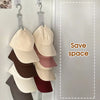 A rack of various colored hats is hanging in a closet for storage.