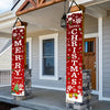 Two vertical red Christmas banners with white snowflakes and green holly accents displayed on stone pillars.