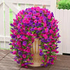 A vibrant display of artificial morning glory hanging vines in shades of pink and purple, arranged around a light-colored ped