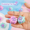 A hand holds a pink and green mini egg-shaped keychain with a hand gesture, used as guessing fist egg party favors.