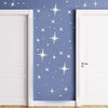 A close-up of a door decorated with silver star wall stickers on a blue-gray background.