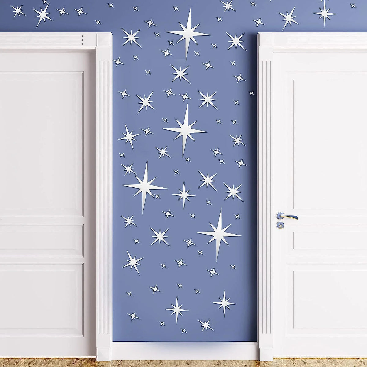 A close-up of a door decorated with silver star wall stickers on a blue-gray background.