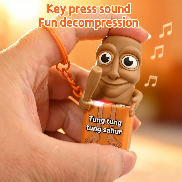 A hand holds a wooden stick man keychain with a glow effect, featuring the text Tung tung tung sahur.