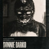 A black and white film poster featuring a menacing figure with glowing eyes and sharp teeth, titled Donnie Darko.