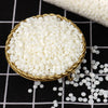 A golden bowl filled with white soy wax flakes is shown on a black and white checkered surface.