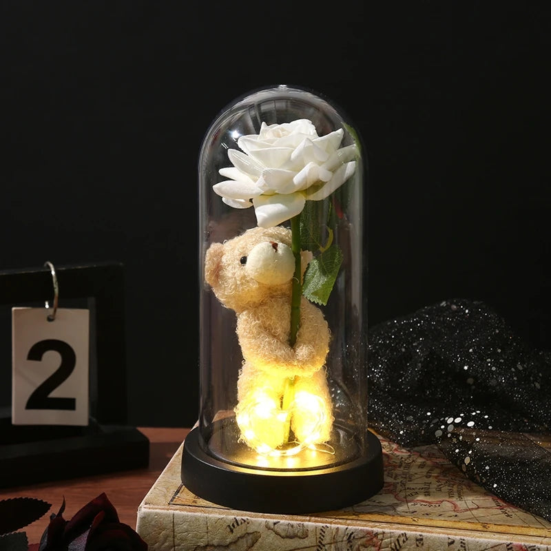 An eternal rose LED decorative flower is displayed inside a glass dome on a dark surface.